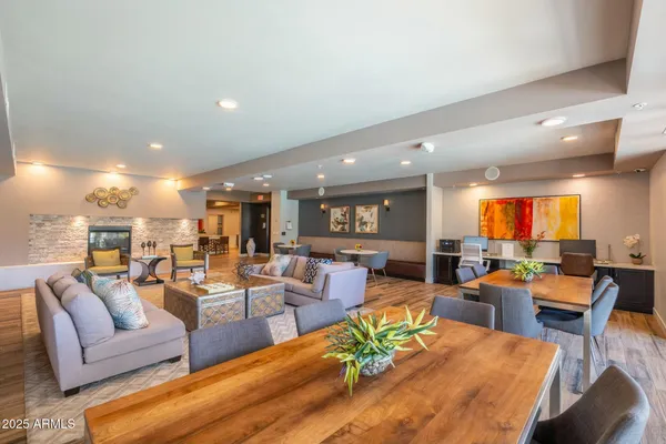 a living room with lots of furniture a rug kitchen view and a large window