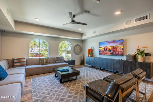 a living room with furniture a large window and a rug