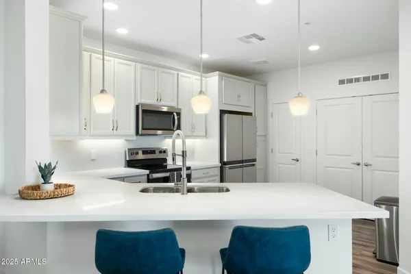 a kitchen with kitchen island a sink stainless steel appliances and cabinets