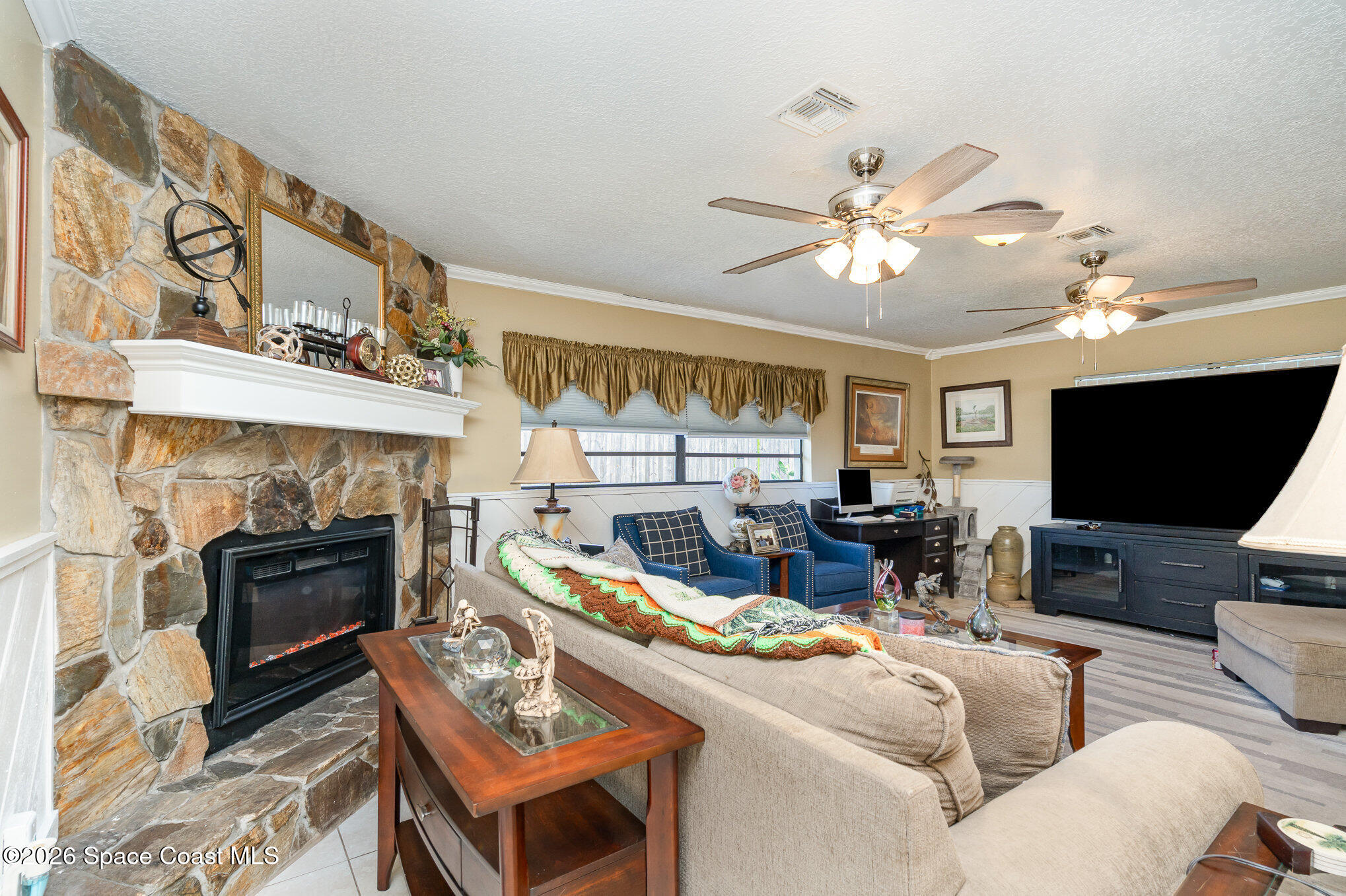 1069 Fairlawn Drive Rockledge, FL 32955 - Photo 14 of 30 a living room with furniture a fireplace and a flat screen tv