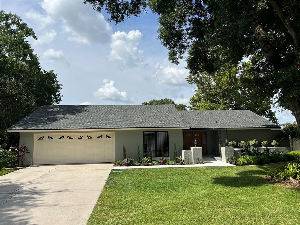 a front view of a house with a yard garage and outdoor seating