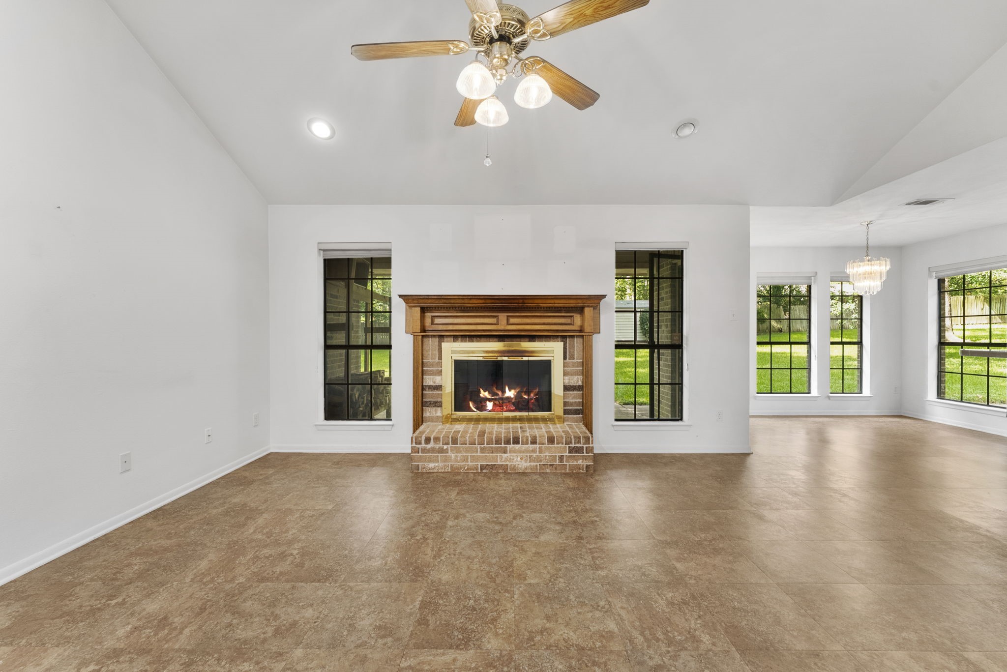 202 Sunset Boulevard Conroe, TX 77303 - Photo 9 of 50 This inviting living space features a charming wood-burning fireplace, perfect for cozy evenings, complemented by abundant natural light and serene backyard views.