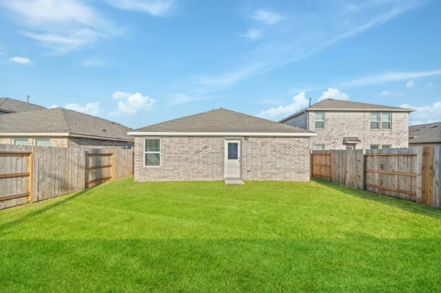 a view of a yard in front of a house with large trees