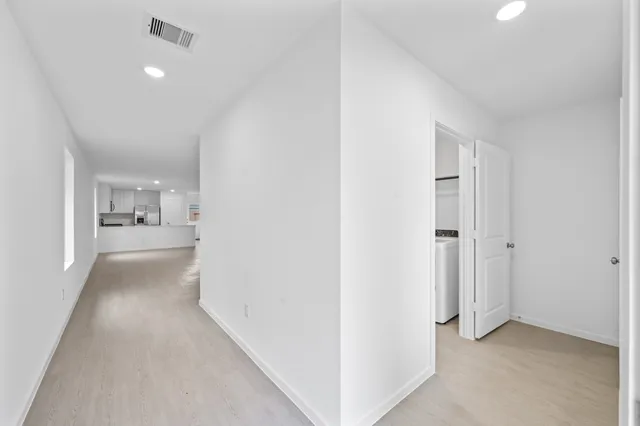 a view of a hallway with kitchen and a sink