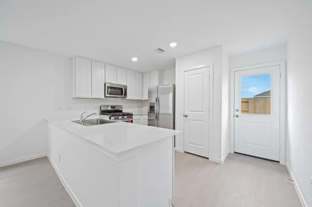 a kitchen with cabinets and a refrigerator