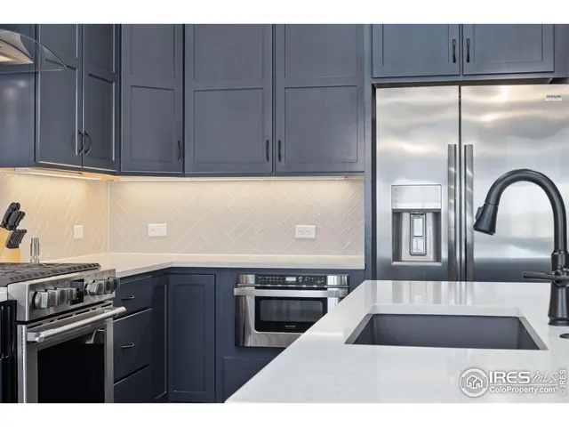 a kitchen with a sink a refrigerator and cabinets