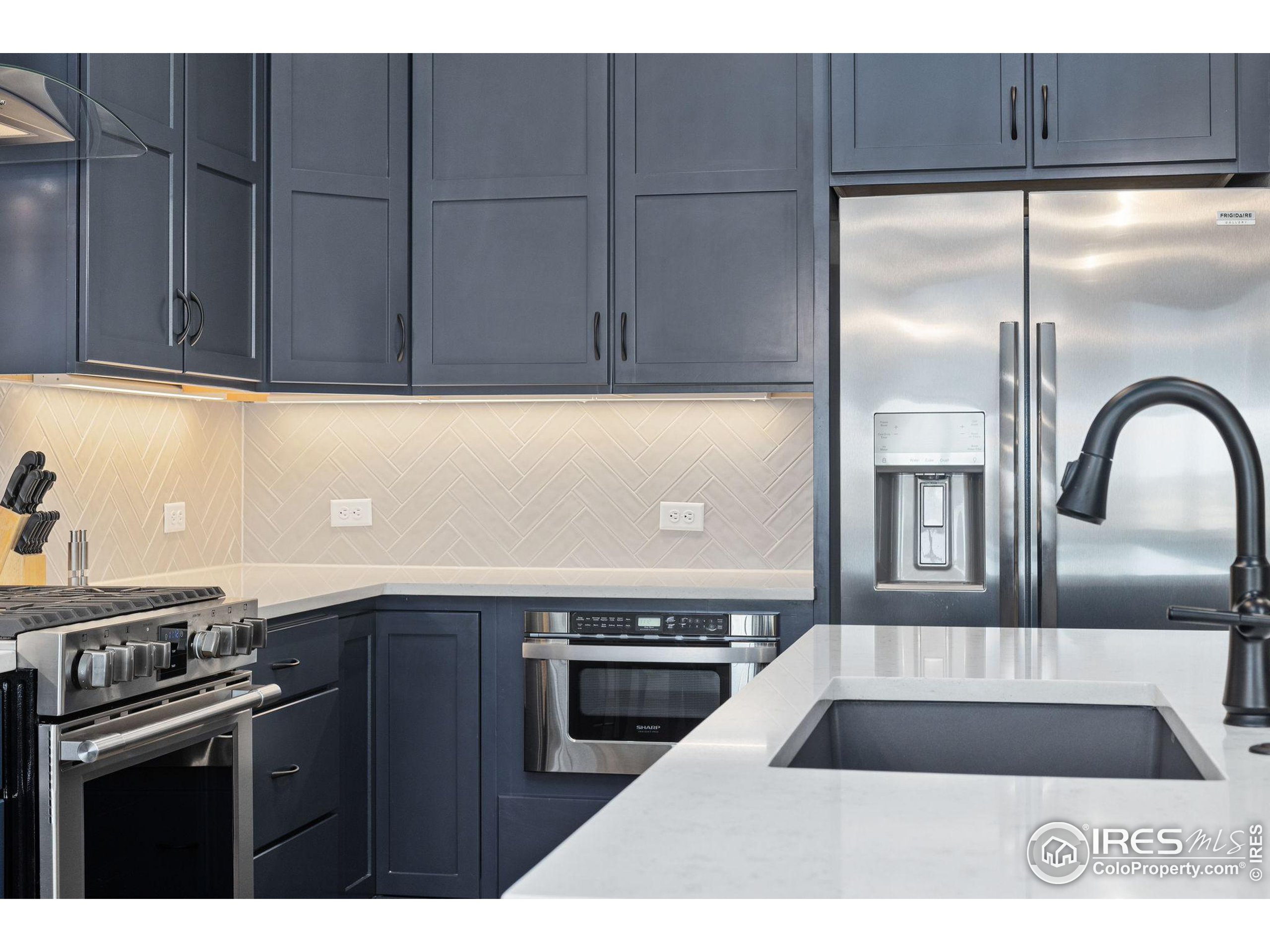 2748 Prairie Flax Street Berthoud, CO 80513 - Photo 11 of 40 a kitchen with a sink a refrigerator and cabinets