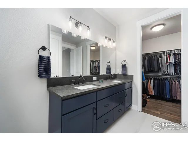 a bathroom with a granite countertop sink a large mirror and a shower