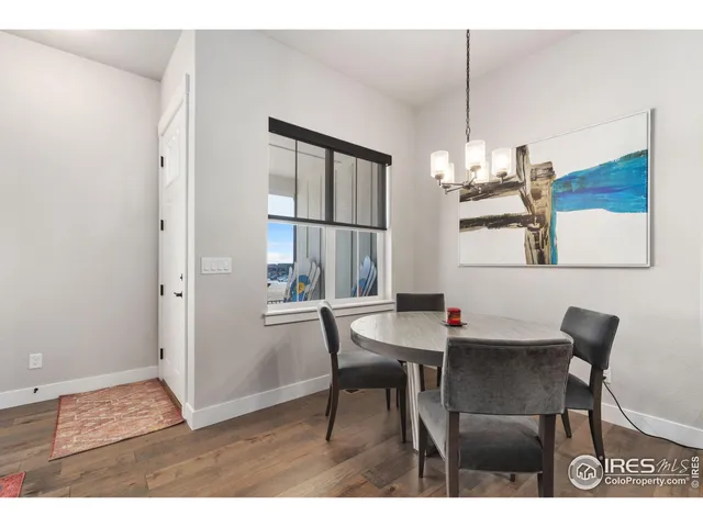 a view of a dining room with furniture a chandelier and wooden floor