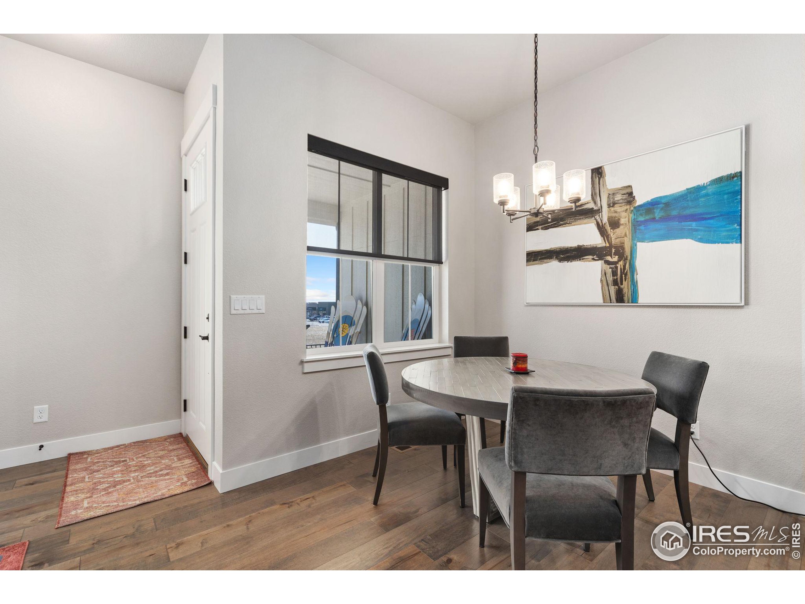 2748 Prairie Flax Street Berthoud, CO 80513 - Photo 4 of 40 a view of a dining room with furniture a chandelier and wooden floor