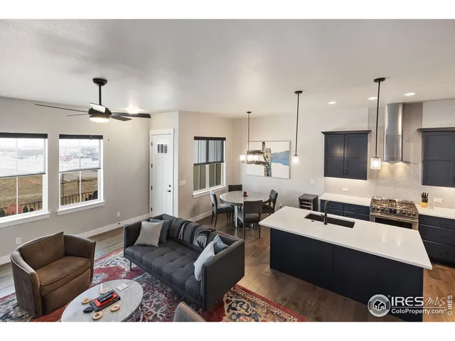 a living room with furniture kitchen view and a large window