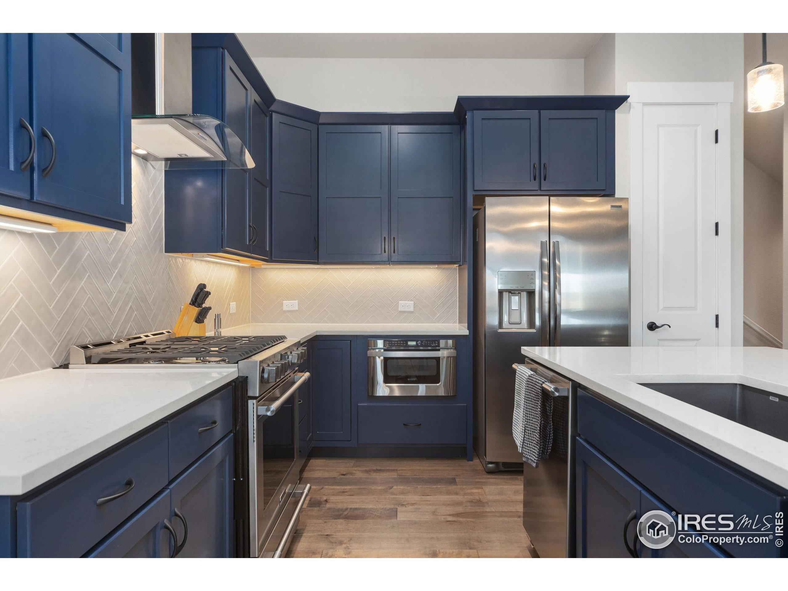 2748 Prairie Flax Street Berthoud, CO 80513 - Photo 9 of 40 a kitchen with a sink stove and refrigerator