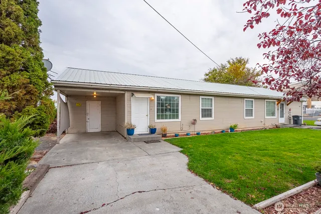 a front view of a house with a garden and yard