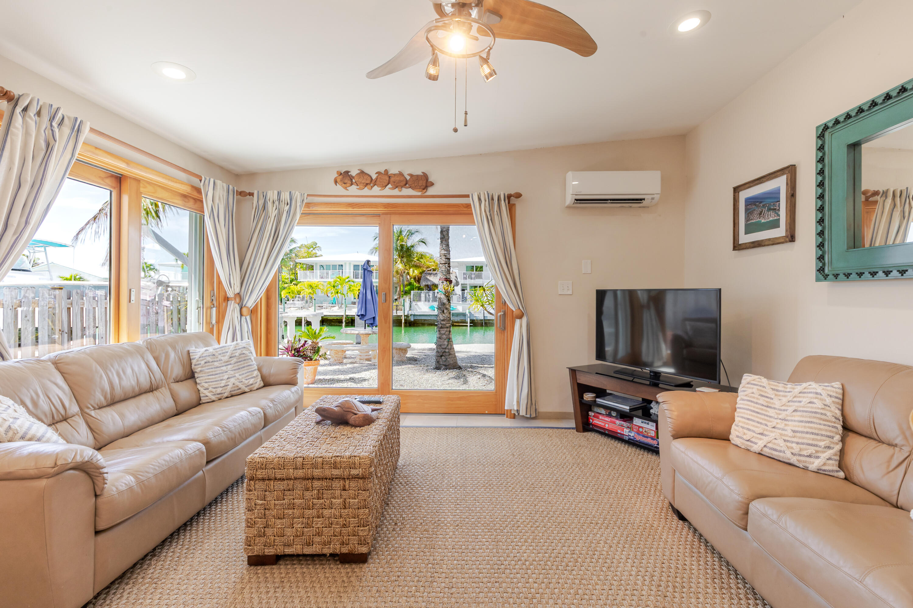 341 3rd Street Key Colony Beach, FL 33051 - Photo 22 of 42 a living room with furniture a flat screen tv and a large window