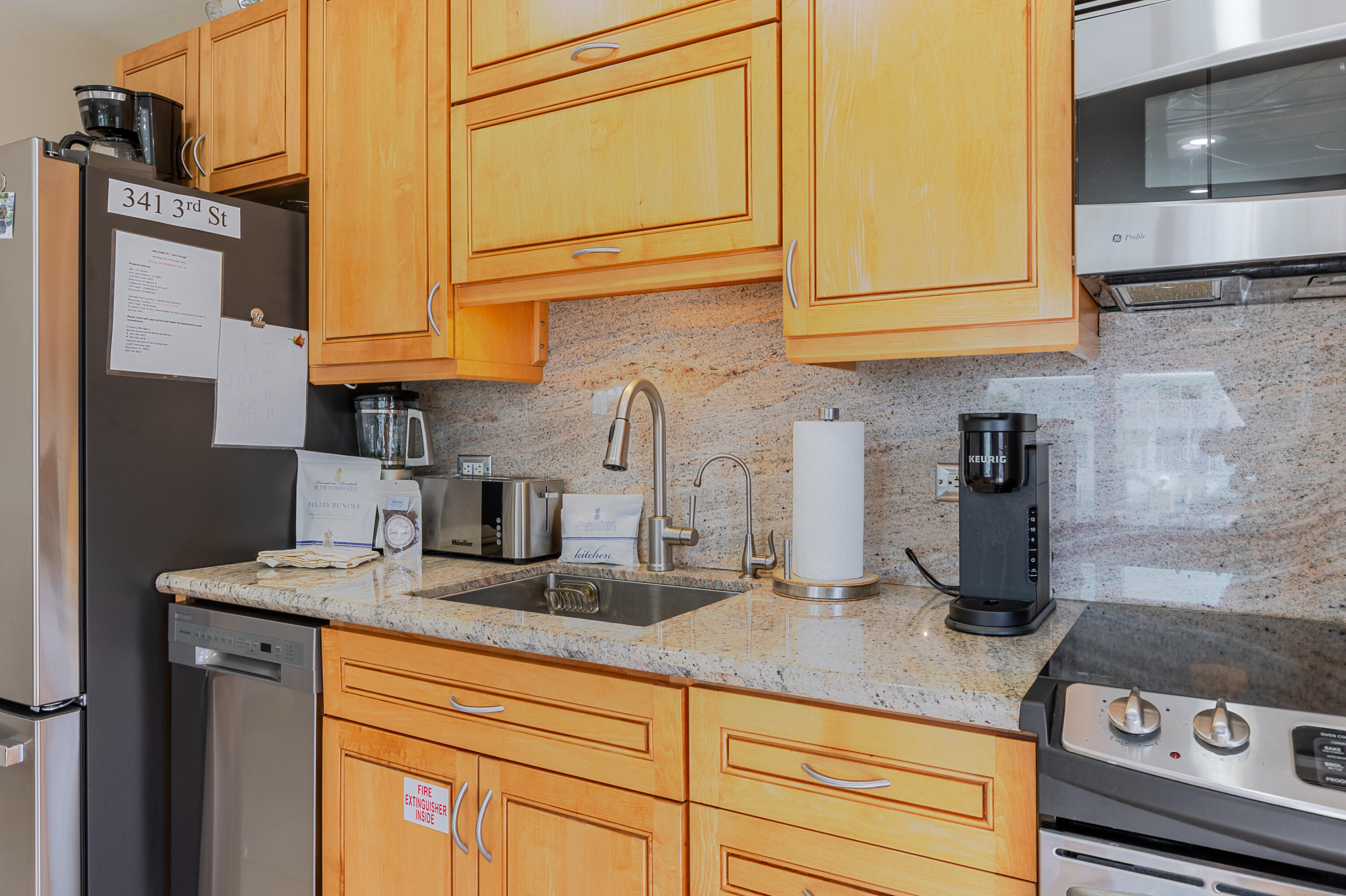 341 3rd Street Key Colony Beach, FL 33051 - Photo 28 of 42 a kitchen with stainless steel appliances granite countertop a sink a stove and cabinets