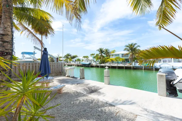 an aerial view of a city with lots of residential buildings and ocean view in back