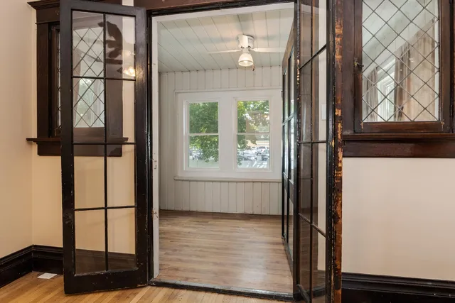an empty room with wooden floor and windows