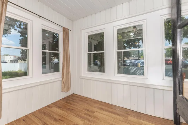 a view of an empty room with closet and wooden floor