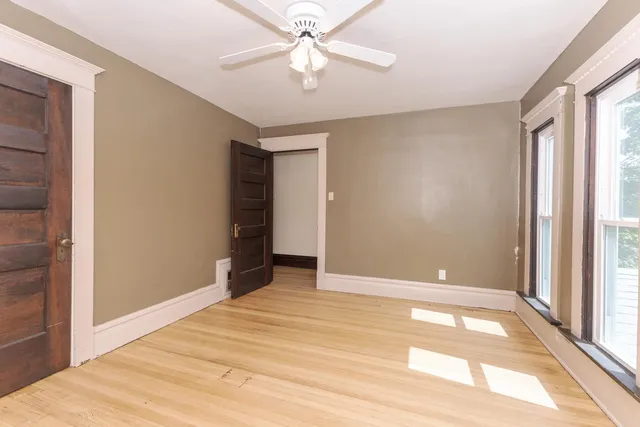 a view of a livingroom with wooden floor and a ceiling fan