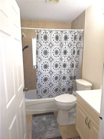 a bathroom with a toilet and a shower curtain