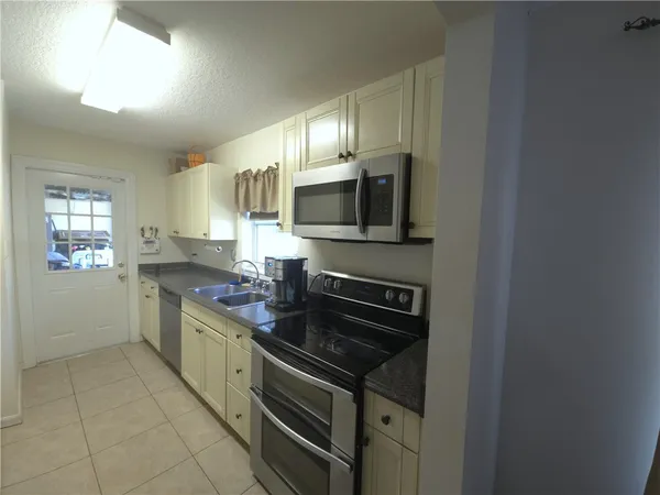 a kitchen with stainless steel appliances a stove sink microwave and cabinets