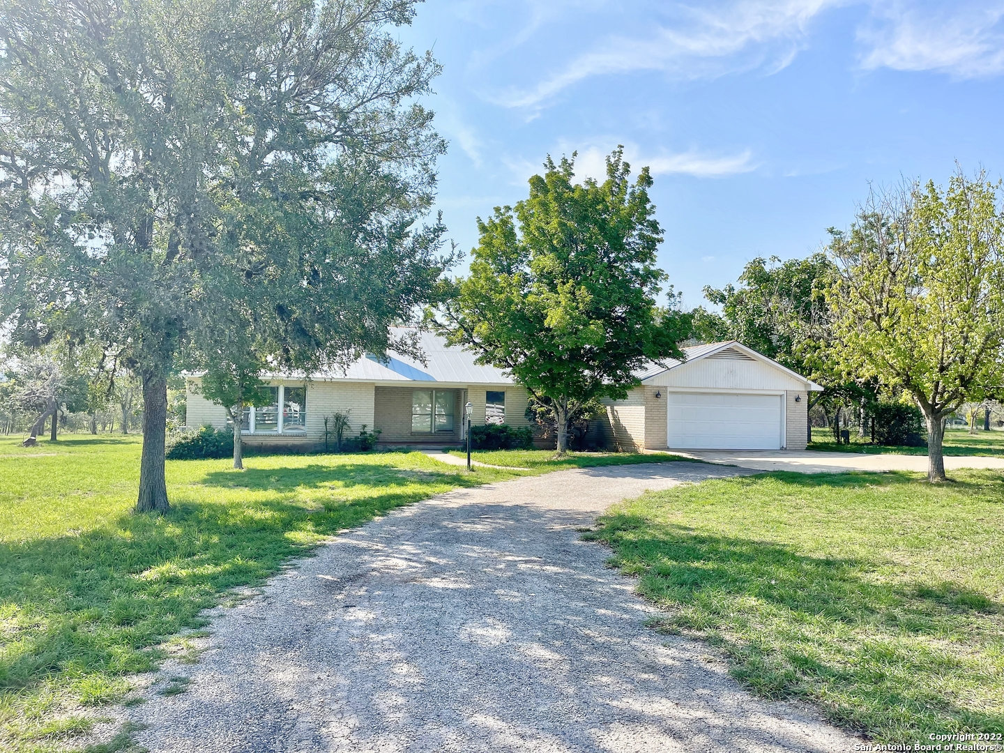 a front view of a house with a yard and trees