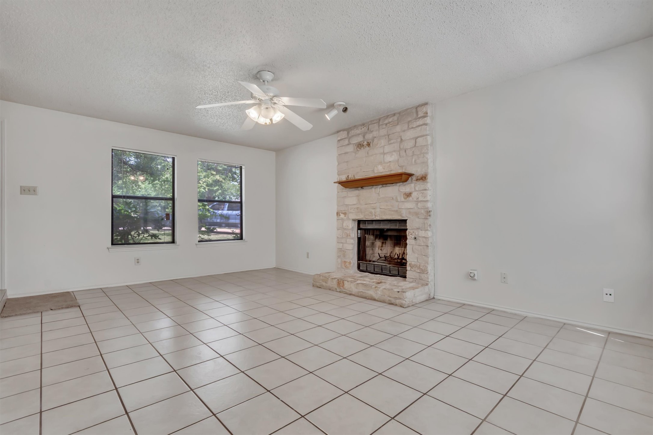 7802 Topawa Cove, Unit B Austin, TX 78729 - Photo 5 of 32 A classic stone fireplace provides a focal point in this comfortable living space.