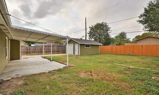 a view of a backyard with grass and a garage