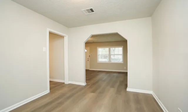 an empty room with wooden floor and a window