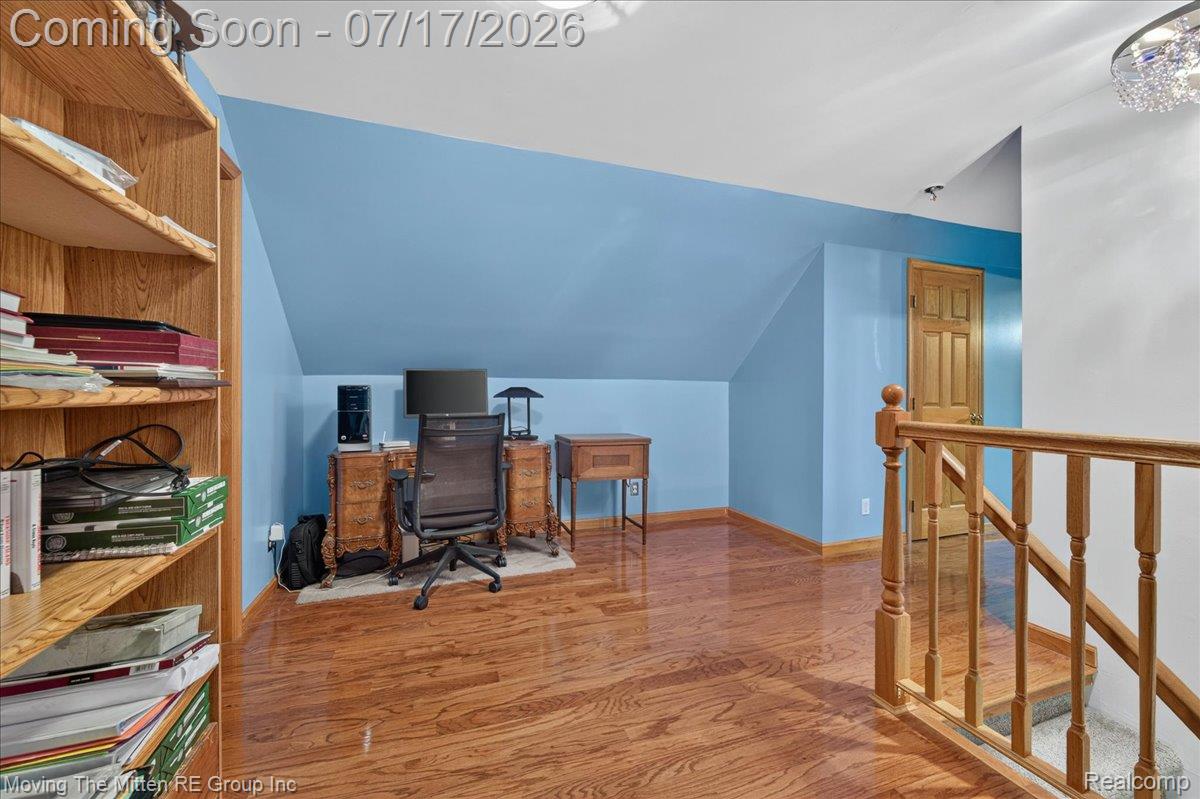 40162 Alden Road Belleville, MI 48111 - Photo 28 of 67 Attic room featuring wood-finish flooring, a wood-finish staircase with balusters, built-in open shelving, and a solid wood-finish door