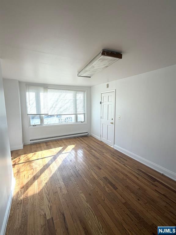 185 Hudson Street Hackensack, NJ 07601 - Photo 3 of 7 an empty room with wooden floor and windows
