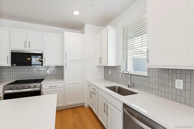 a kitchen with a sink a stove and cabinets