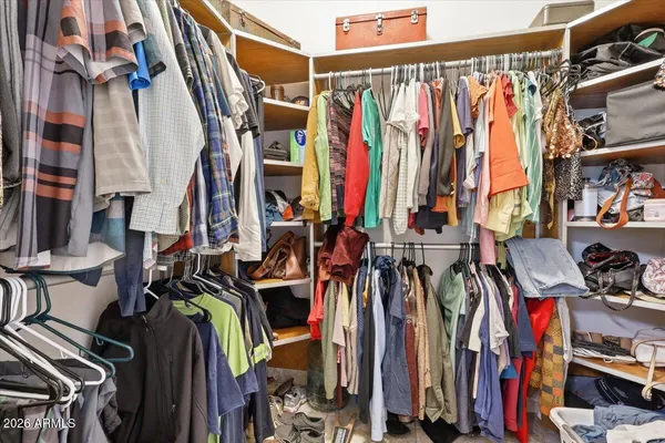 a view of walk in closet with clothes and shoes