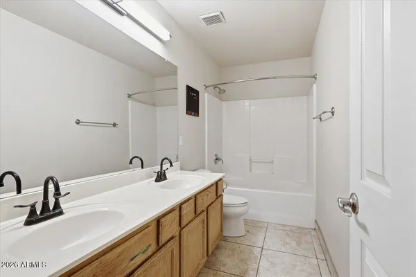 a bathroom with a double vanity sink a toilet and shower