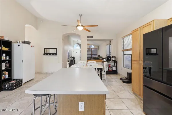 a large kitchen with a table chairs refrigerator and a stove