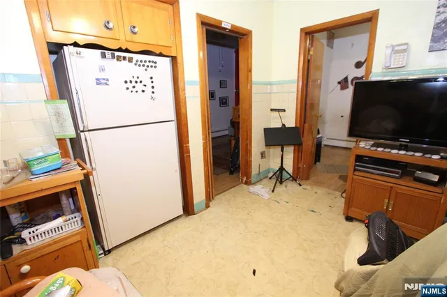 a room with furniture a flat screen tv and a refrigerator