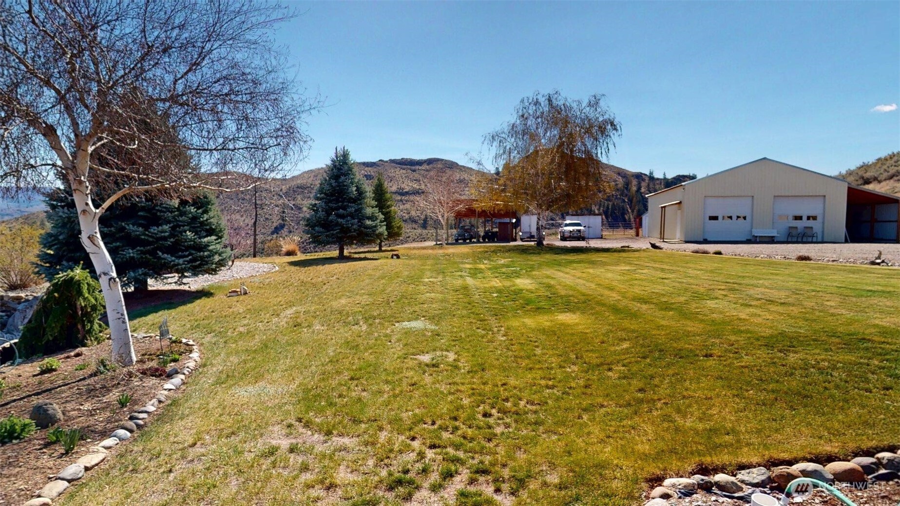1811 Pine Creek Road Tonasket, WA 98855 - Photo 18 of 38 a view of a house with a swimming pool and a yard