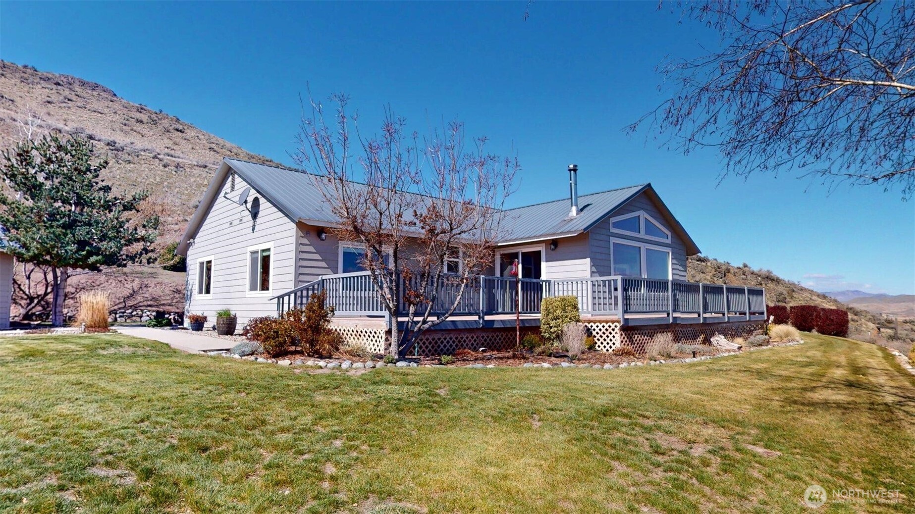 1811 Pine Creek Road Tonasket, WA 98855 - Photo 2 of 38 a front view of a house with a yard