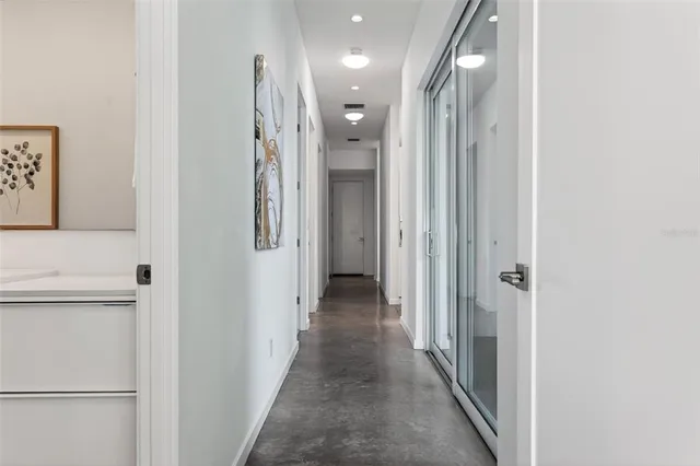 a view of a hallway with closet and a bathroom