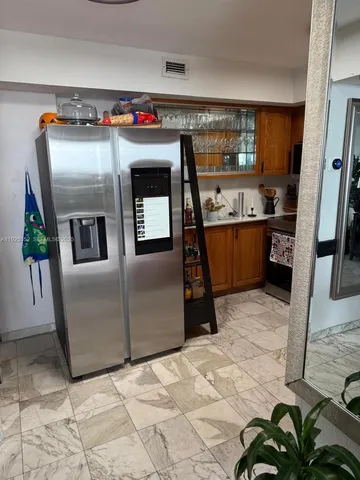 a kitchen with stainless steel appliances kitchen island granite countertop a refrigerator and a stove