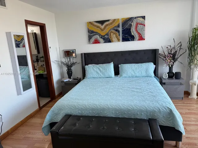 a bedroom with a bed and a painting on the wall