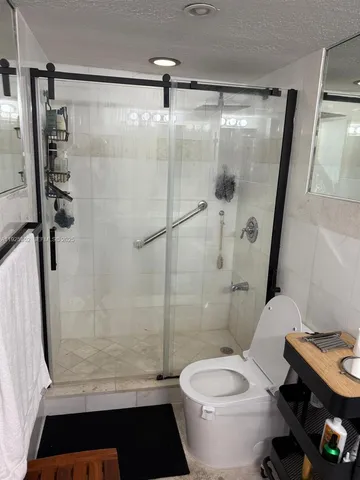 a bathroom with a shower a toilet and a sink