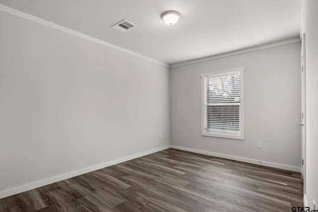 a view of a room with wooden floor and a window