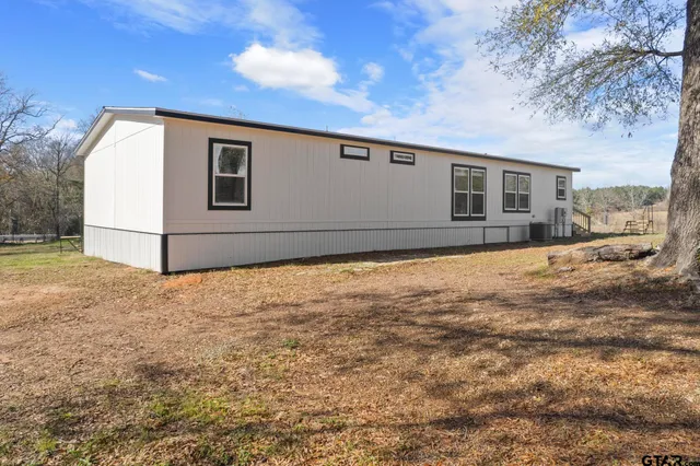 a view of a house with backyard and trees