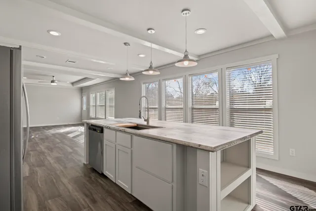 a kitchen with stainless steel appliances granite countertop a stove and a wooden floors