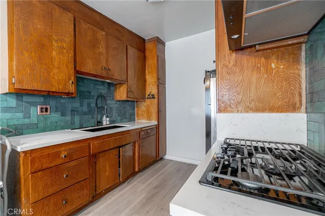 a kitchen with stainless steel appliances granite countertop a refrigerator a stove and a wooden floors