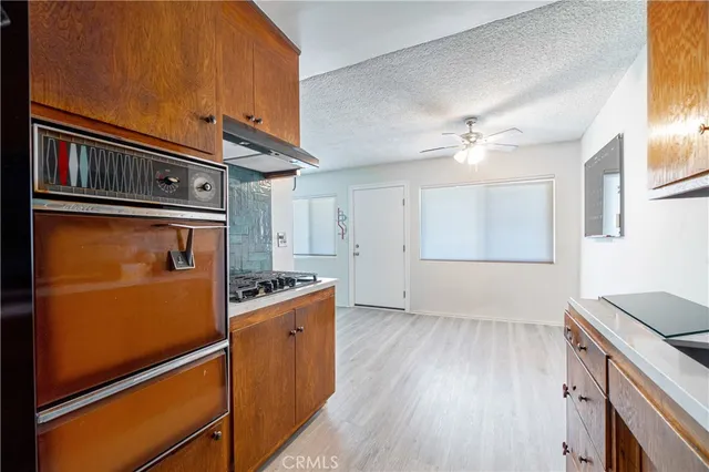 a kitchen with granite countertop a refrigerator stove and sink