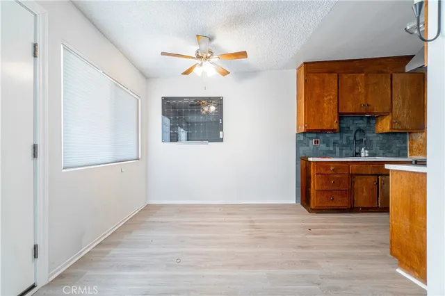 a view of an empty room with a window and a ceiling fan