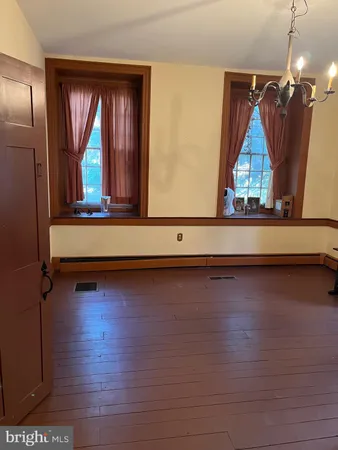 a living room with wooden floor and a window