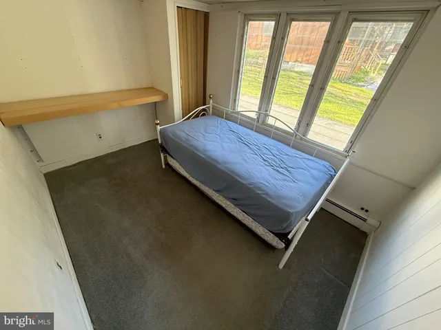 a bed sitting in a bedroom next to a window